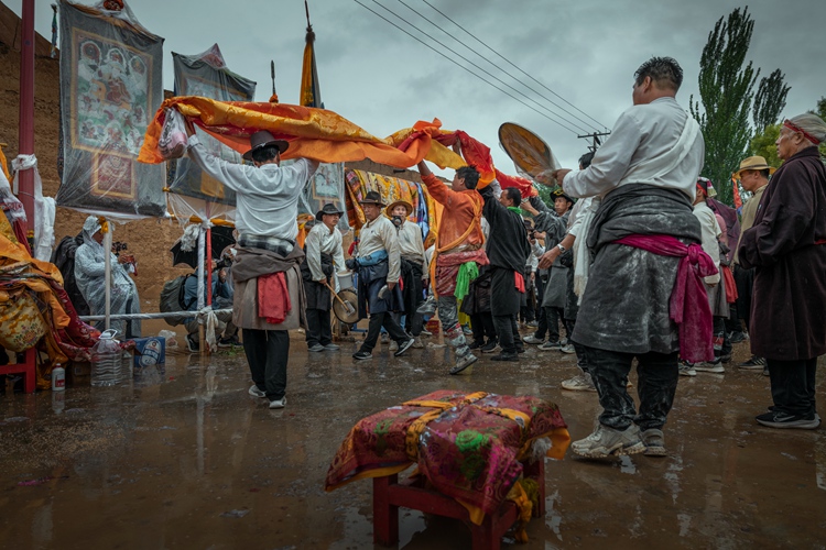 hk_c_圖11，法師在助手幫助下，舉起人們敬奉的錦緞，向神像跳祭祀舞.jpg