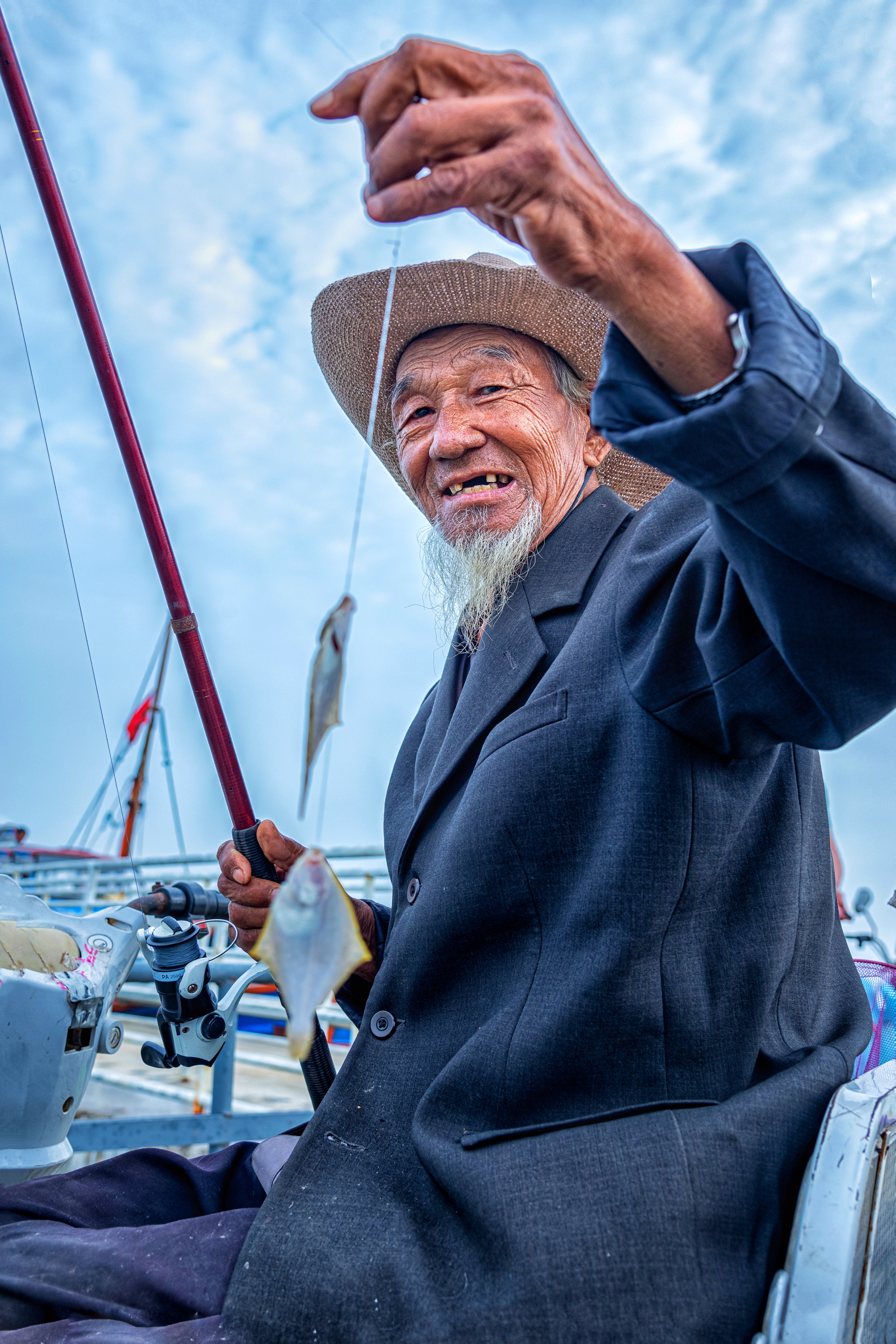 hk_c_開心就好 2020年九月份，山東省蓬萊市某海濱碼頭，一位近八十歲的老人在釣魚，一次釣上了二條，魚雖然小，但是收穫的是開心！海石花 coral張建中.jpeg