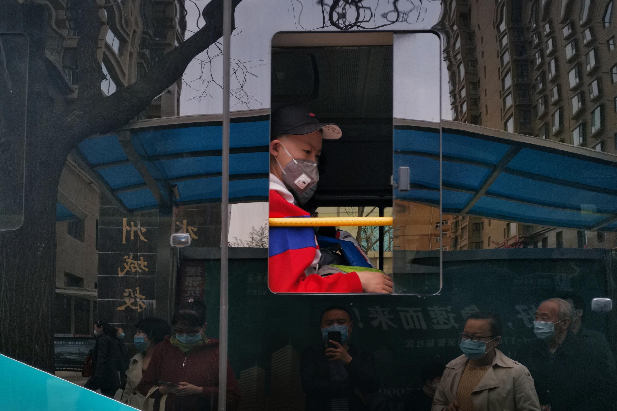 hk_c_6、峰  抓拍疫情下公交車上的孩子和公交車玻璃反光出來的車站等候進站的乘客。.jpeg